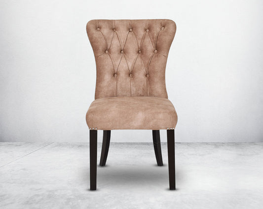 Dining chair upholstered in fabric front with tufted back and birchwood legs. Stainless steel decorative ring at the back with stainless steel rivets on the sides.