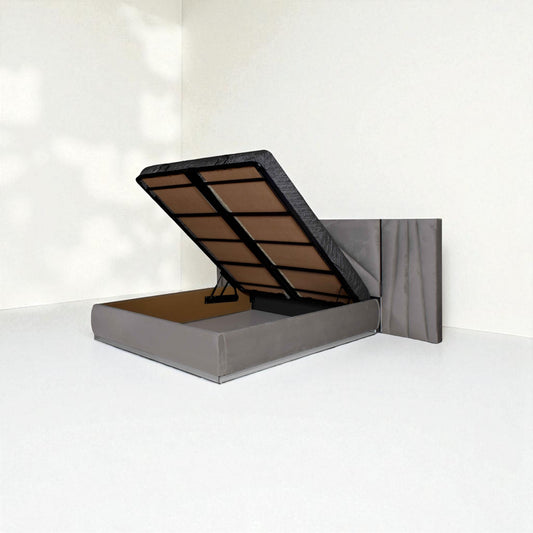 Grey hydraulic bed with mattress lifted open to reveal under-bed storage, in a minimal room.