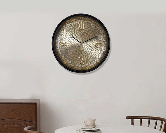 Round wall clock in croc etched design with a matt antique brass finish in black polish with table and chair