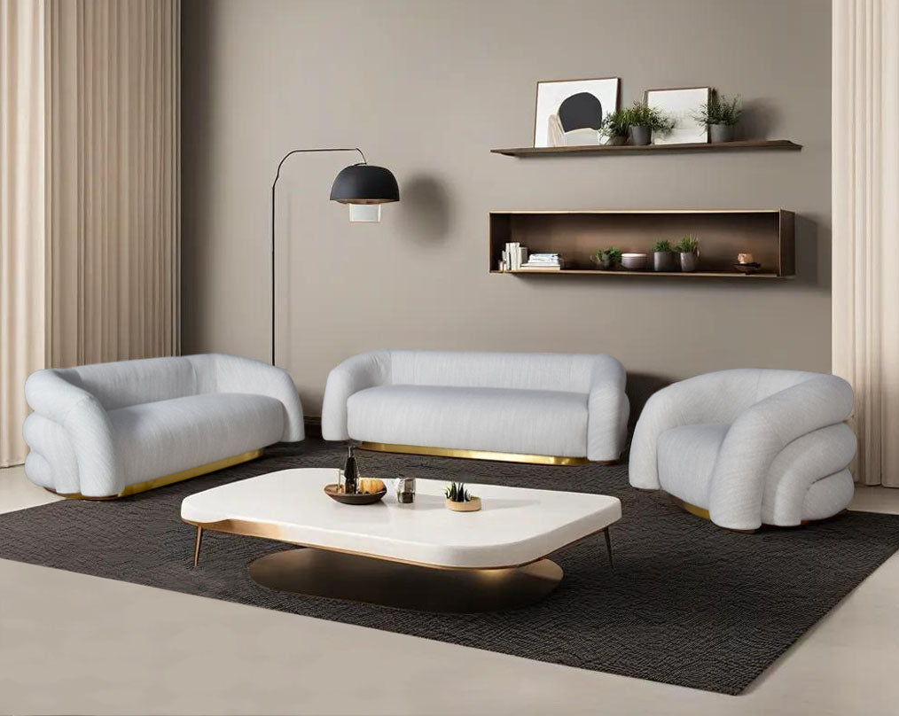 This modern chic 3+2+1 sofa in soft form upholstered in high-quality fabric crafted like soft bun with puffy rounded/ tubular back & armrest with stainless steel velvet brushed gold base is a design