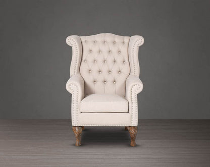 Wing arm chair  front upholstered in fabric with tufted back and stainless steel rivets and oak wood legs