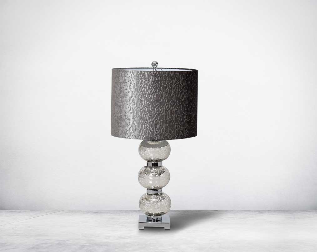Table lamp with tinted crystal orbs on a silver-plated metal base with black translucent fabric shade.
