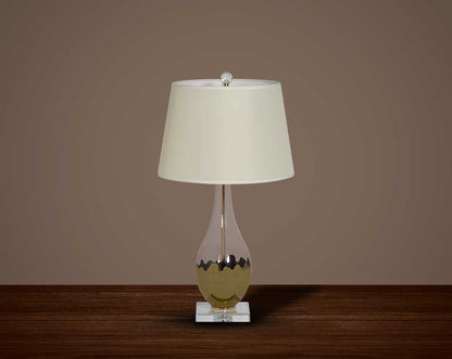 Table lamp with metallic silver and glass decorative base with translucent fabric shade.