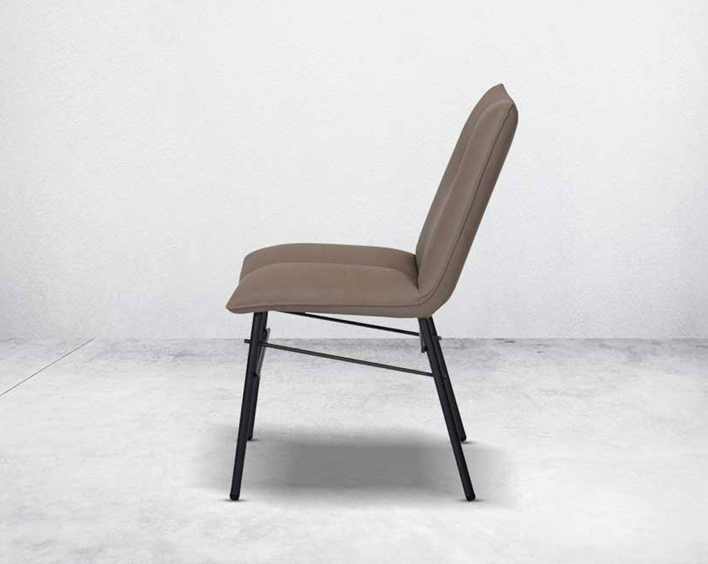 This dining chair is crafted in faux leather with matt black metal legs. It is sleek and modern in design side view