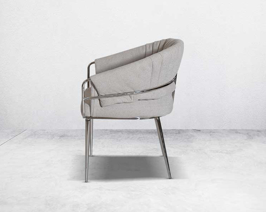 This predominantly eclectic and contemporary dining chair is upholstered in boucle fabric with glossy stainless steel frame & legs 