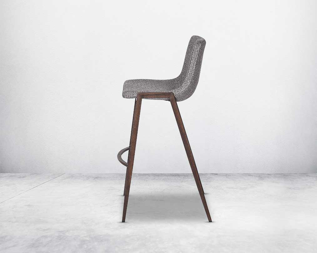 this wooden bar stool is a striking mix of industrial and modern. The supple seat, upholstered in fabric sits atop a stainless steel base in wood finish.