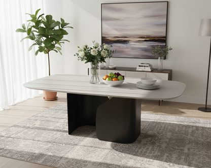 Modern dining room with a white table, decorative items, and a large painting on the wall.
