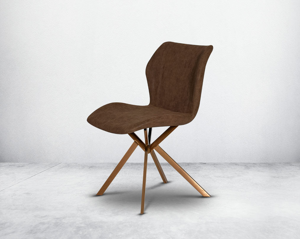 Dining chair upholstered in faux leather with high polished stainless steel legs plated in rose gold.