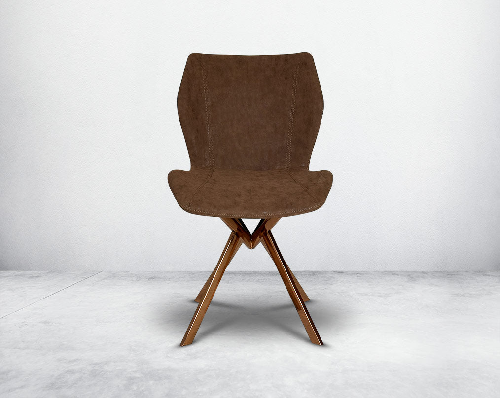 Dining chair front  upholstered in faux leather with high polished stainless steel legs plated in rose gold.