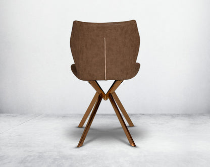 Dining chair back upholstered in faux leather with high polished stainless steel legs plated in rose gold.