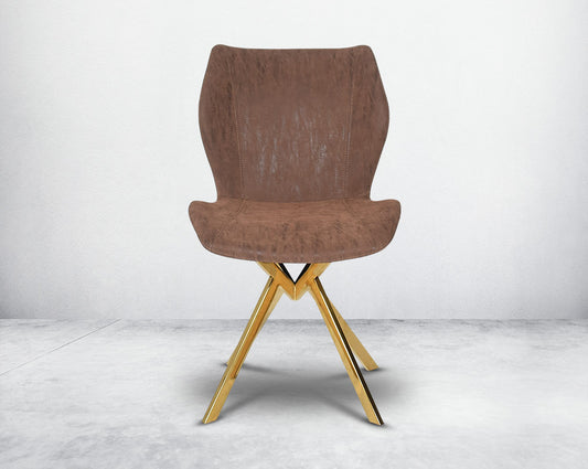 Dining chair upholstered in faux leather with high polished stainless steel legs plated in gold front view