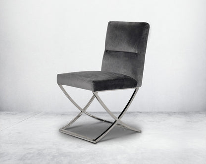 Dining chair upholstered in fabric with high polished stainless steel legs in a cross design.