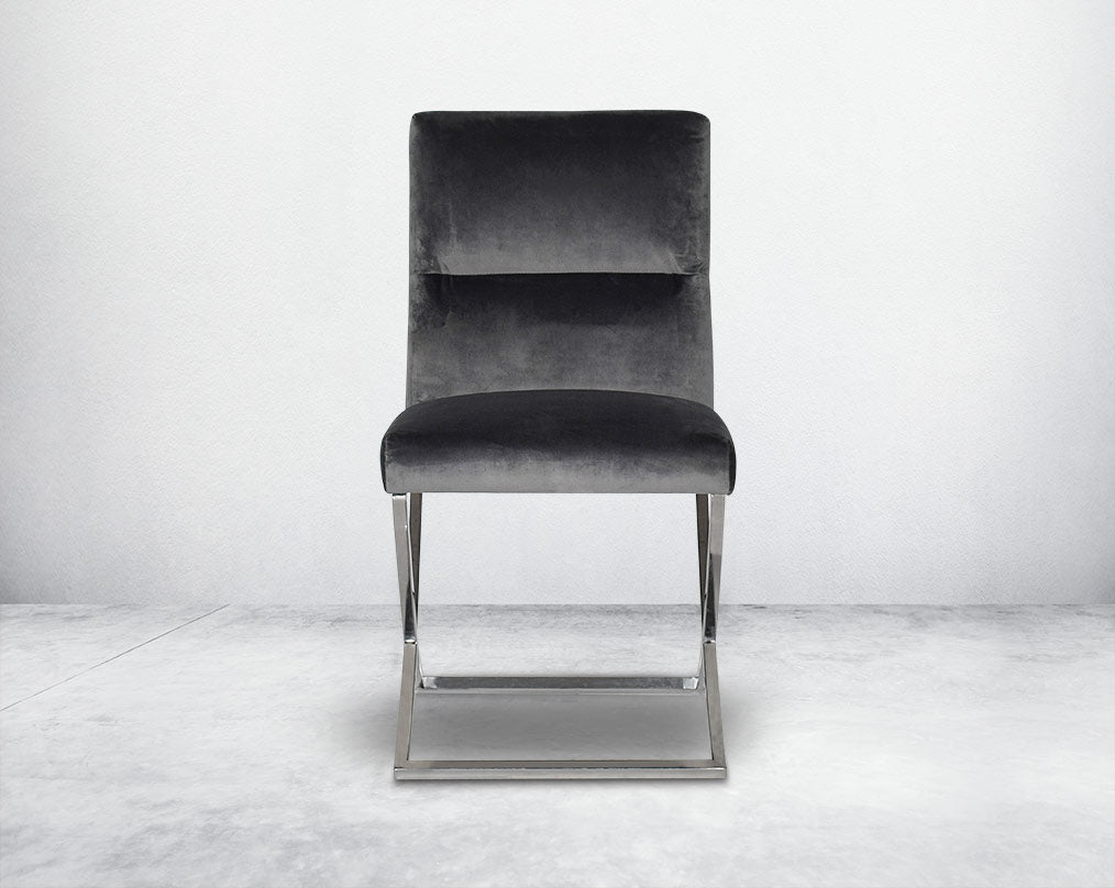 Dining chair  with front upholstered in fabric with high polished stainless steel legs in a cross design.