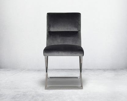 Dining chair  with front upholstered in fabric with high polished stainless steel legs in a cross design.