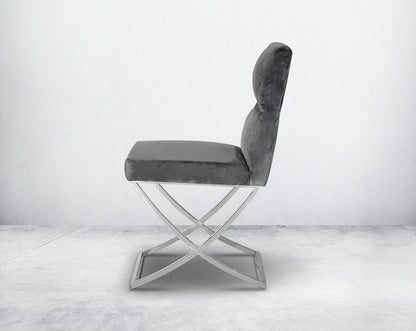 Dining chair upholstered in fabric with high polished stainless steel legs in a cross design.