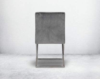Dining chair with back upholstered in fabric with high polished stainless steel legs in a cross design.