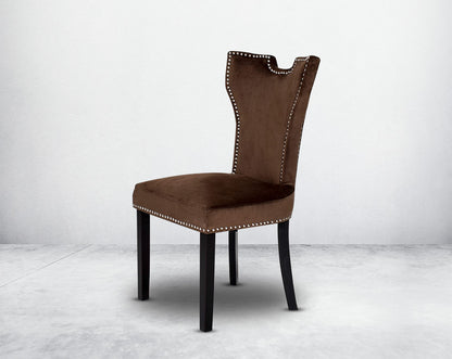 Dining chair upholstered in fabric with legs in wood. Stainless steel decorative ring at the back with stainless steel rivets.