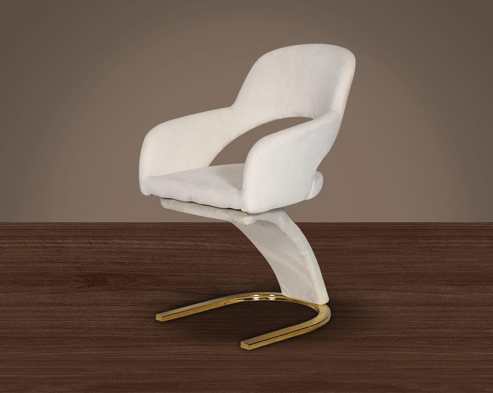 This dining chair features an extraordinary design with a backrest and a cushioned seat upholstered in velvet. It has a horseshoe motif gold plated metal base which adds a modern glamorous look to any space