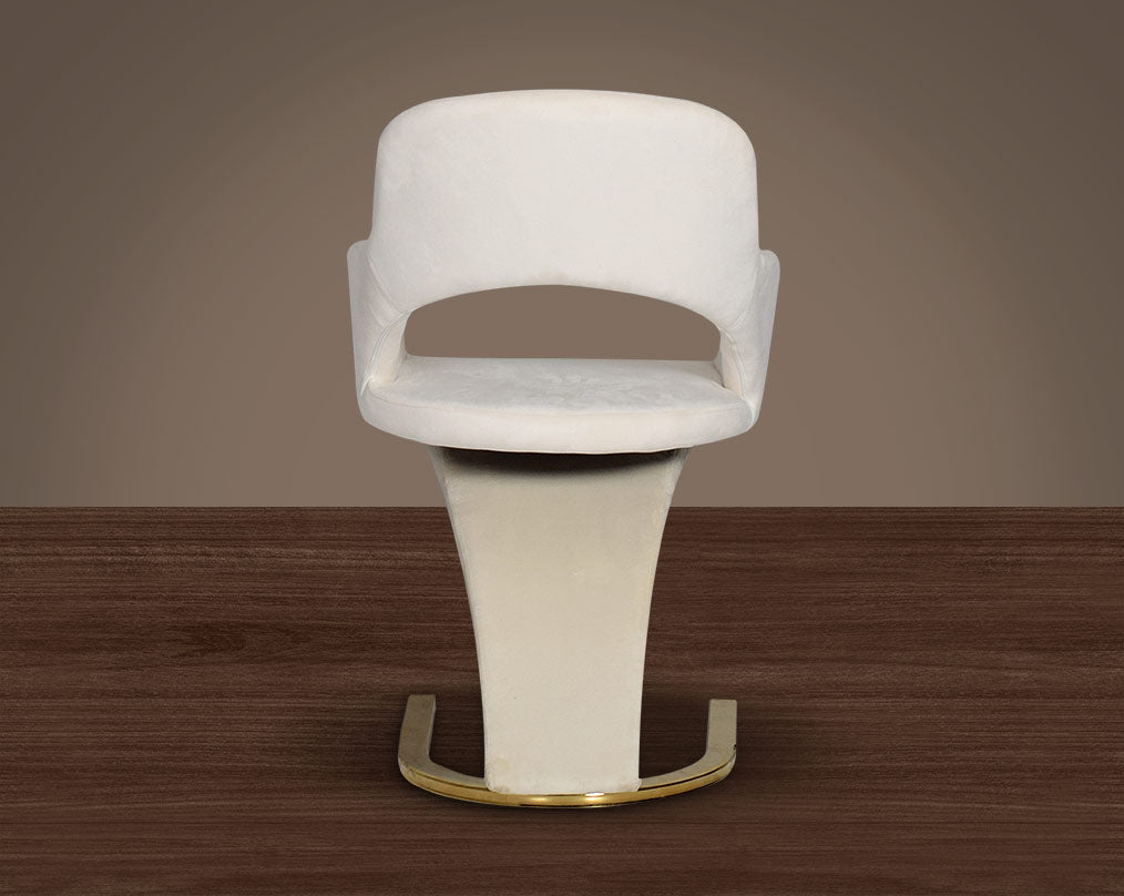 This dining chair with back  features an extraordinary design with a backrest and a cushioned seat upholstered in velvet. It has a horseshoe motif gold plated metal base which adds a modern glamorous look to any space