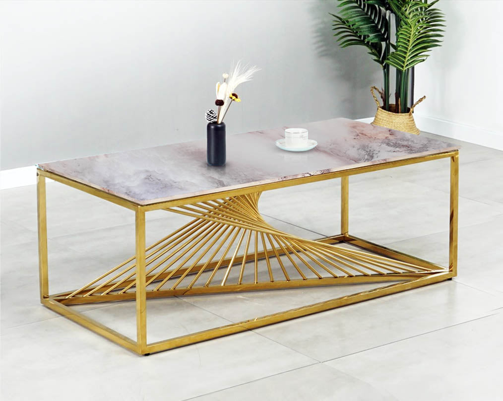 Coffee table with marble finish glass top and gold plated stainless steel base in a geometric pattern with green plant 