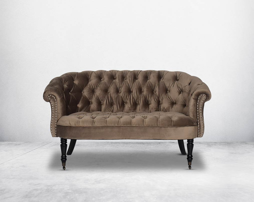 Two Seater Wing lounge chair upholstered in velvet fabric with tufted back and seat with steel rivets on the arms.