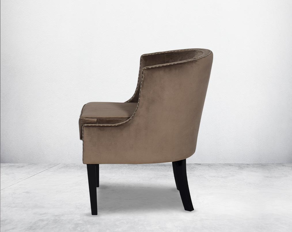 Wing arm chair upholstered in velvet fabric and tufted with steel rivets and legs in brown oak.