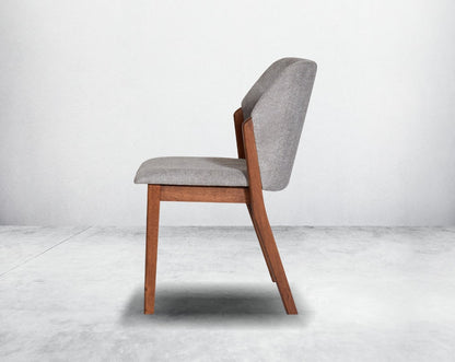 Dining chair upholstered in fabric with legs in walnut representing a sleek and modern style.