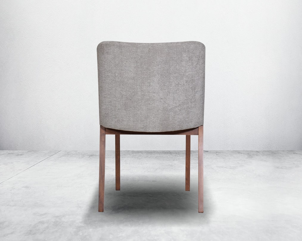 Dining chair back with upholstered in fabric with legs in walnut representing a sleek and modern style.