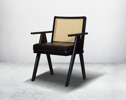 This appealing solid wooden dining chair with comfy cushioned seat & rattan backrest with curved armrest & geometrical leg design in dark walnut finish in retro style.