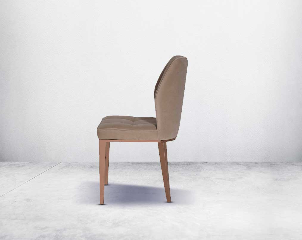 Dining chair upholstered in velvet fabric with side view high polished rose gold stainless steel legs.