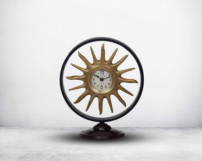 Round table clock in antique matt brass in sun ray design motif.