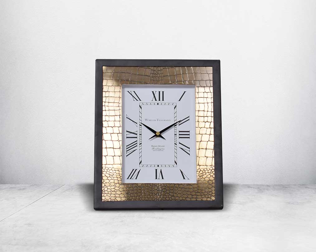 Rectangular table clock in front with  croc etched design in matt antique brass finish & matt black frame with Roman numerals in rich contemporary design.