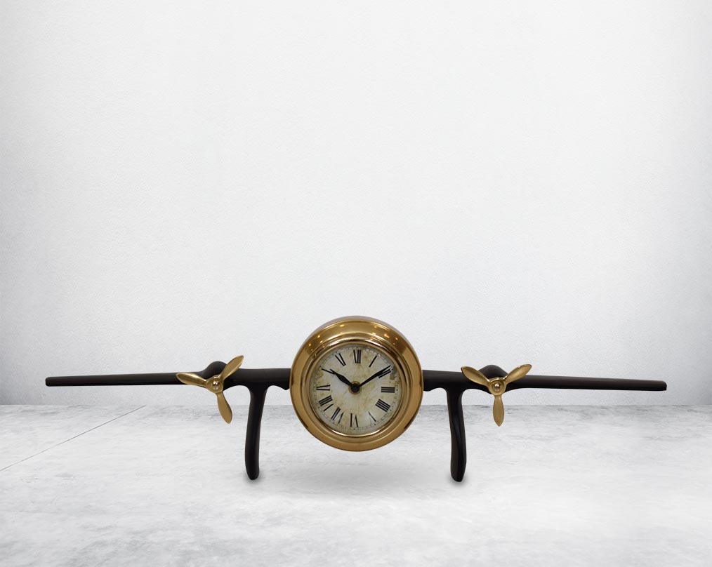 This unique vintage airplane propeller table clock comes with the clock in the center of the wings. This antique clock is made out of brass in antique matt finish. It has a white dial with Roman Numerals for a vintage look. This is a great statement piece