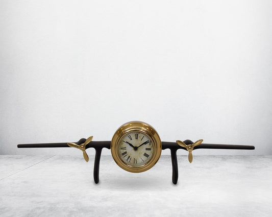 This unique vintage airplane propeller table clock comes with the clock in the center of the wings. This antique clock is made out of brass in antique matt finish. It has a white dial with Roman Numerals for a vintage look. This is a great statement piece