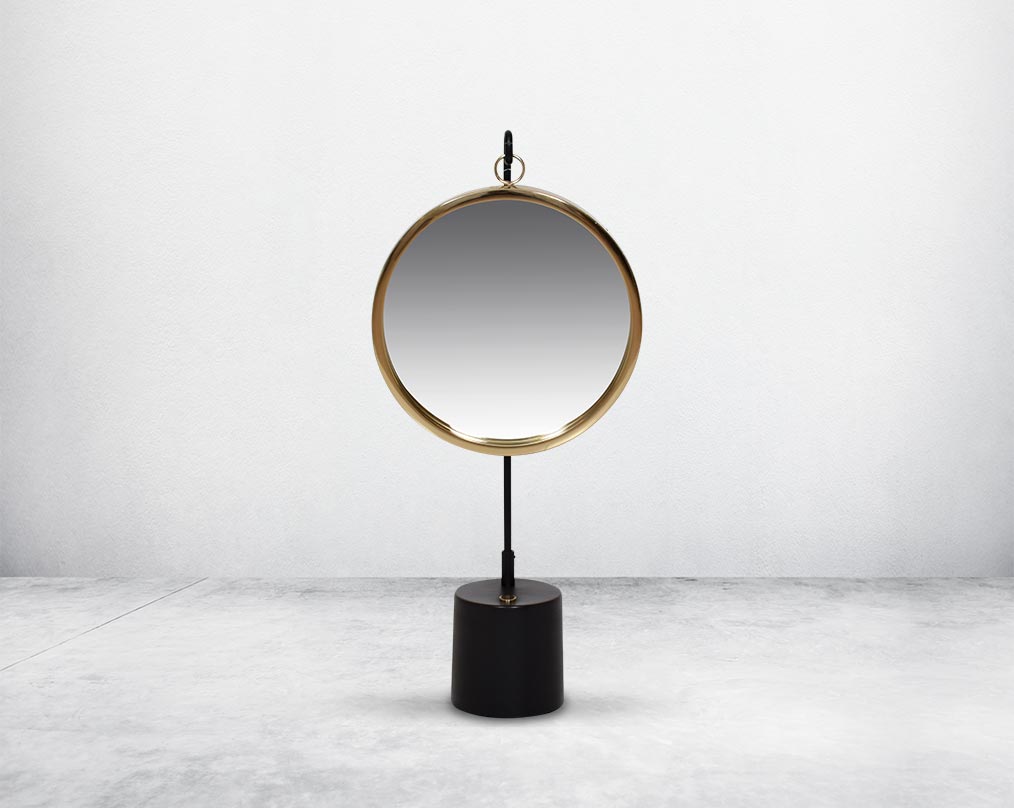 Round table dresser mirror suspended on a hook in shiny antique brass & matt black finished base. The look is very retro modern.