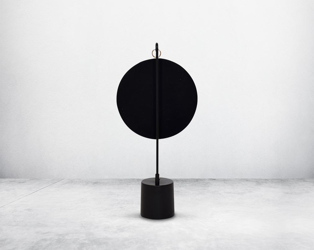 Round table dresser back mirror suspended on a hook in shiny antique brass & matt black finished base. The look is very retro modern.