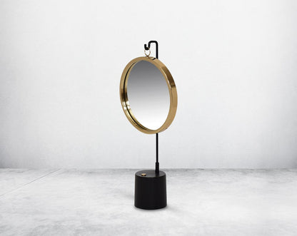 Round table dresser mirror suspended on a hook in shiny antique brass & matt black finished base. The look is very retro modern.
