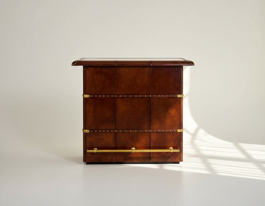 Bar counter in distressed cognac leather with a vintage look with brass hardware and wooden slats The bar counter has a copper top and comes with storage.