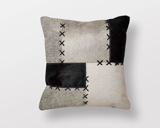 White, black, and grey hair on & a leather cushion.