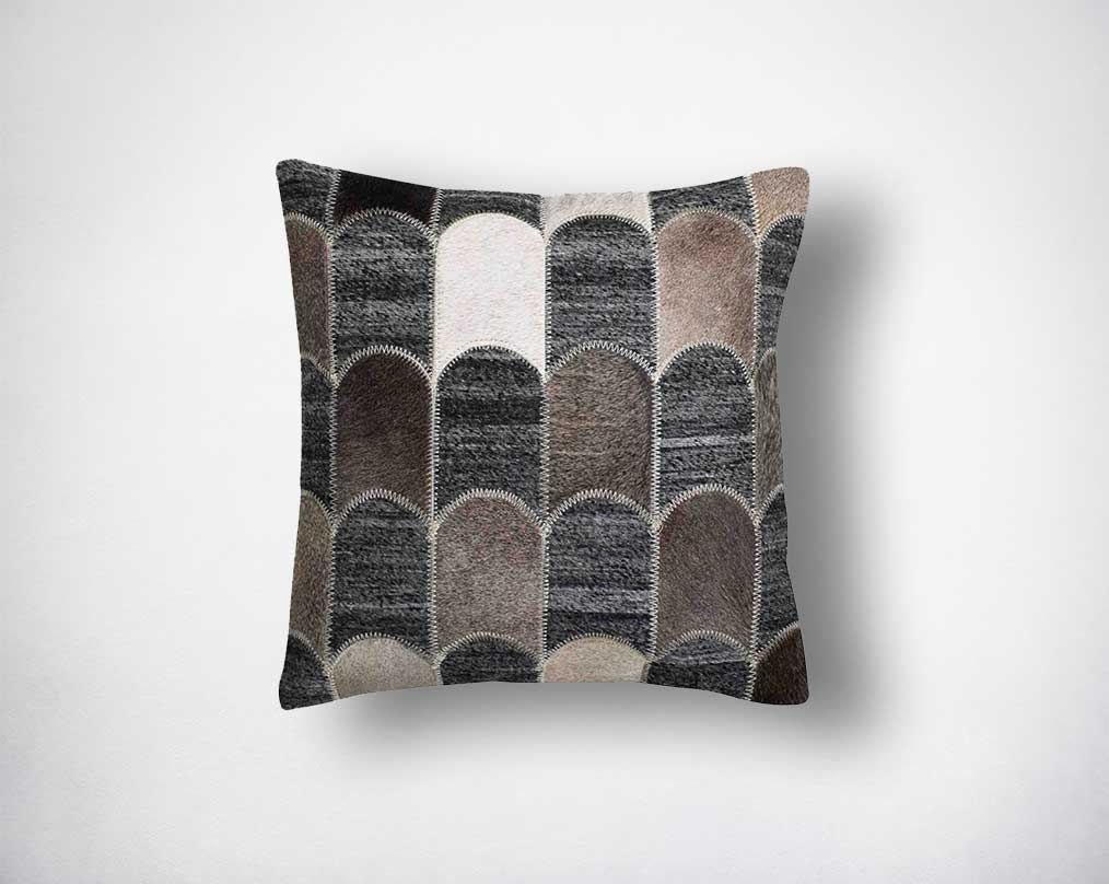Grey, brown and black cut-out fabric and leather hair on the cushion.