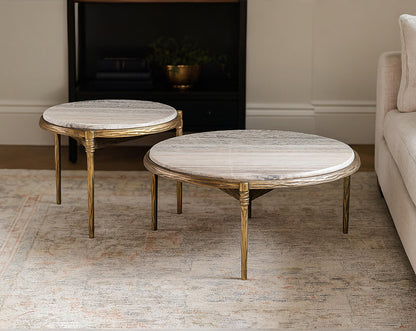 Two round marble coffee tables with wooden legs in a living room setting.