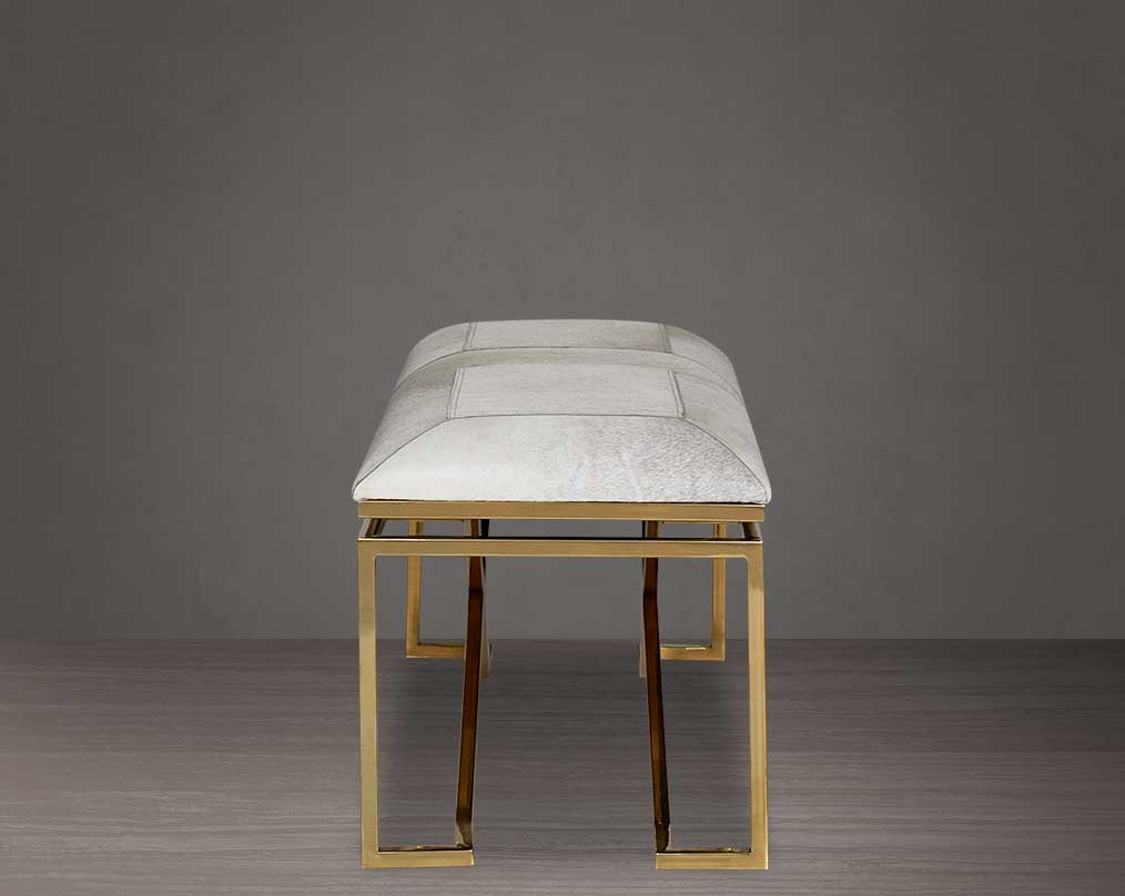 Double bench upholstered in light grey hide seat and high polished gold stainless steel legs in a contemporary, cross design.