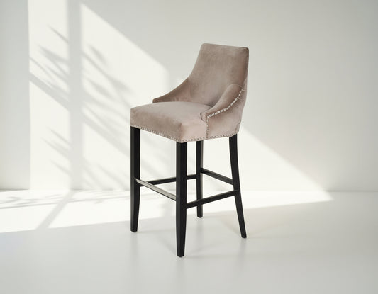 Bar chair upholstered in fabric with buttoned tufted back and silver rivets, the stool has a stainless steel front bar as a foot rest with legs in dark vintage brown wood 