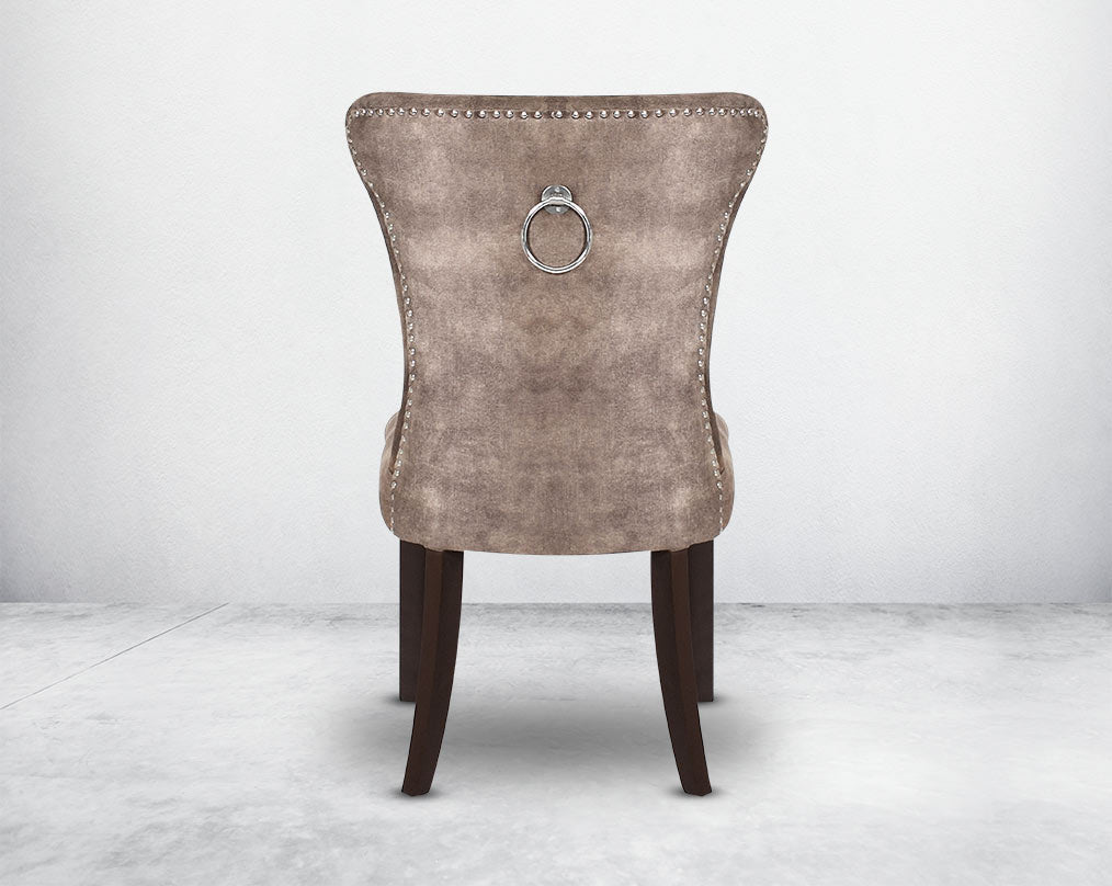 Dining chair back with  upholstered in fabric with tufted back and birchwood legs. Stainless steel decorative ring at the back with stainless steel rivets on the sides.