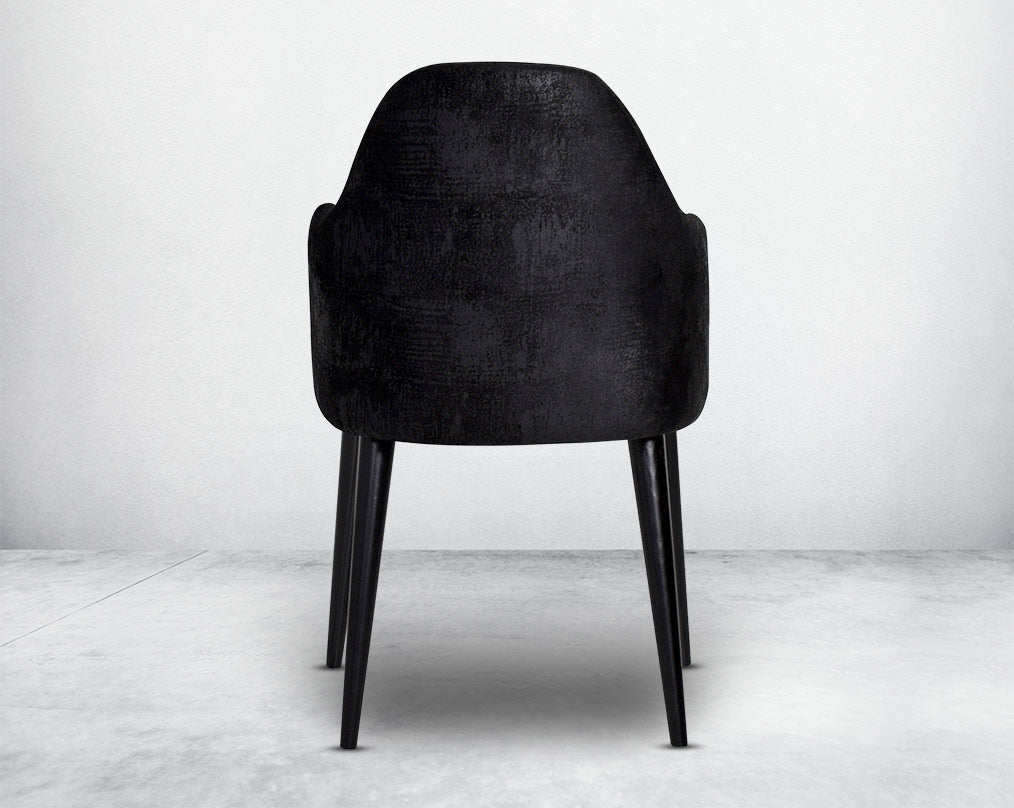 Dining chair upholstered in fabric with back view legs in wood.