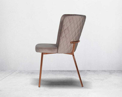 Minimalistically designed chair with criss-cross stitch padded fabric in rose gold finish stainless steel legs in contemporary design.