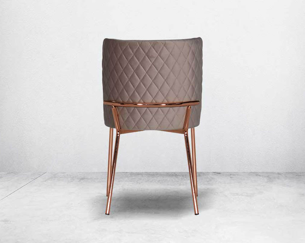 Minimalistically designed chair back with criss-cross stitch padded fabric in rose gold finish stainless steel legs in contemporary design.