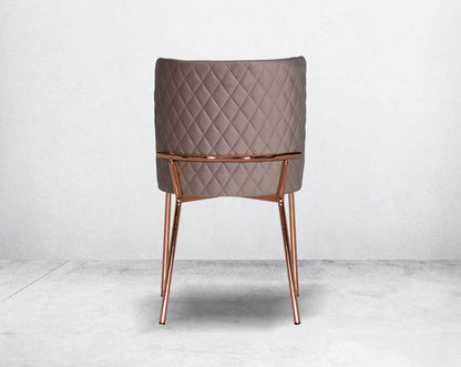 Minimalistically designed chair back with criss-cross stitch padded fabric in rose gold finish stainless steel legs in contemporary design.