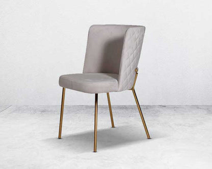 Minimalistically designed chair with criss-cross stitch padded fabric in gold finish stainless steel legs in contemporary design.