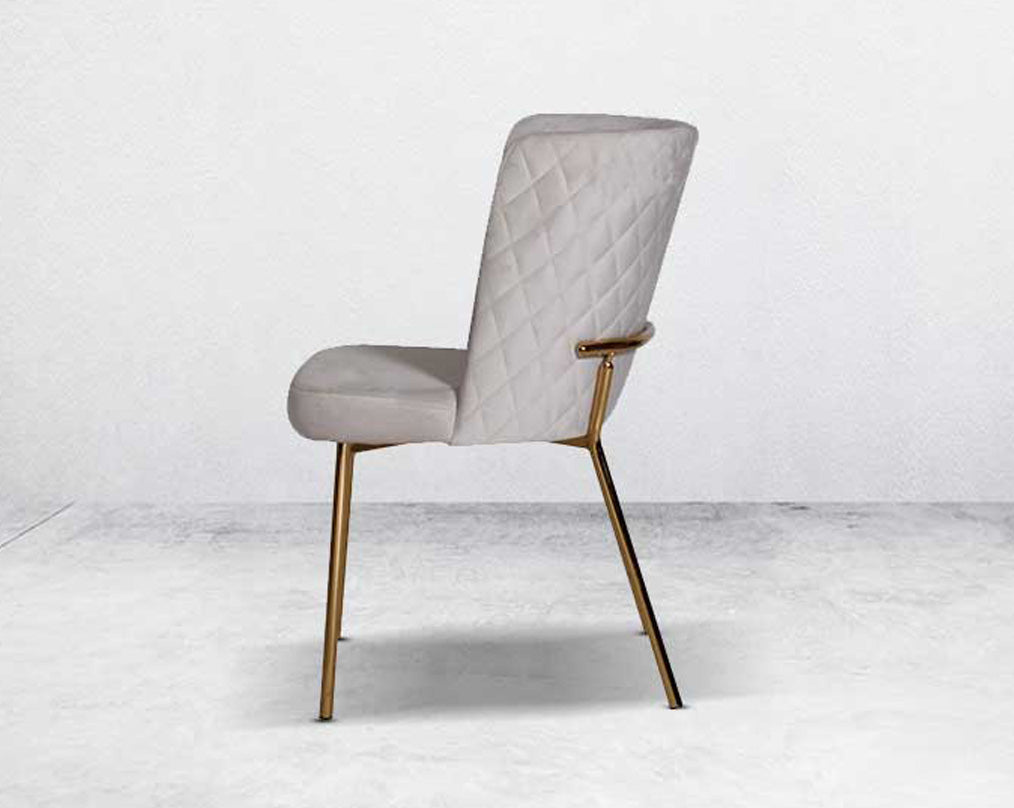 Minimalistically designed chair with criss-cross stitch padded fabric in gold finish stainless steel legs in contemporary design.